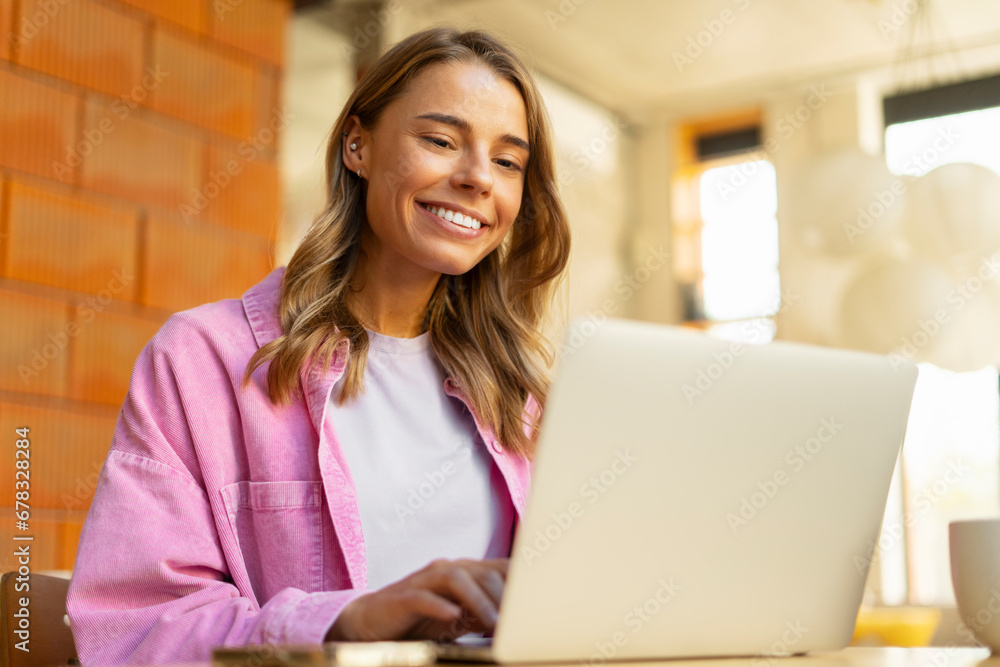 Portrait smiling beautiful woman using laptop computer in modern office. Happy copywriter typing on keyboard working freelance project. Technology, successful business concept Portrait smiling beautiful woman using laptop computer in modern office. Happy copywriter typing on keyboard working freelance project. Technology, successful business concept