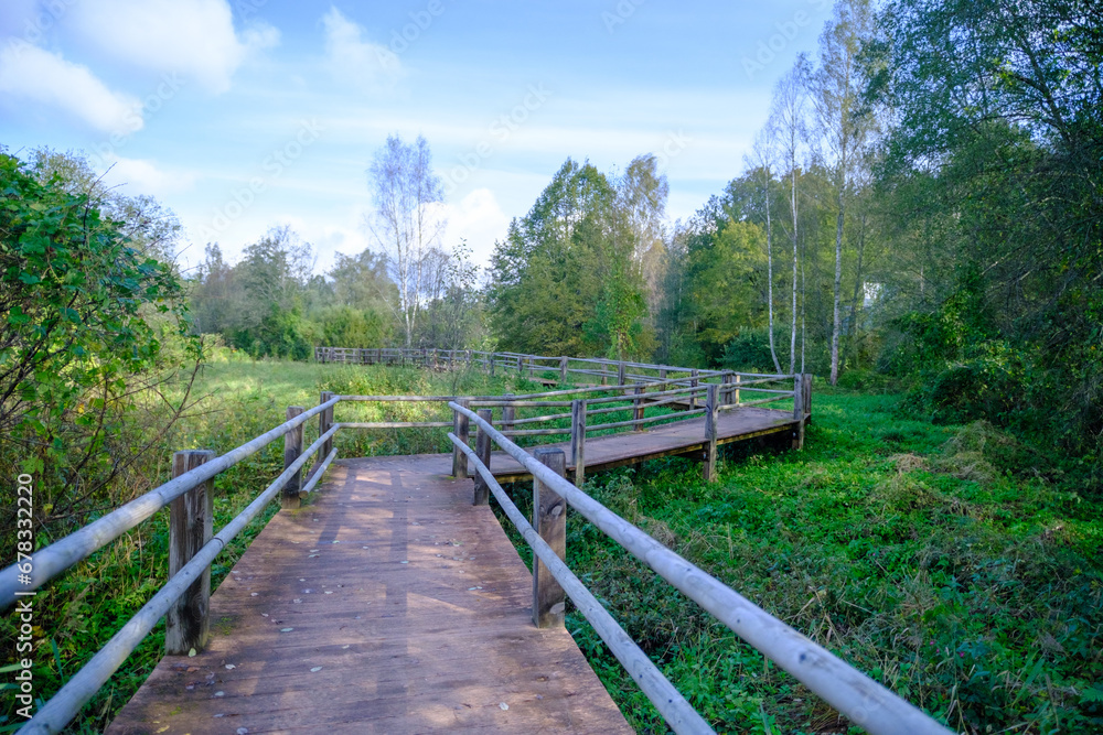 A wooden bridge, a path with railings as a place for tourists to walk to a difficult-to-access environmental object in Latvia