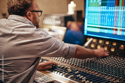 Music producer working with audio equipment in a recording studio photo