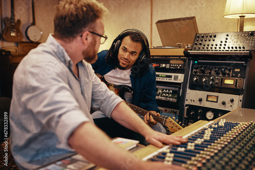 Musician and music producer working together in a recording studio photo