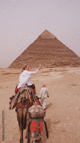 European woman on the camel a front of Giza pyramid in Cairo Egypt travel photography 