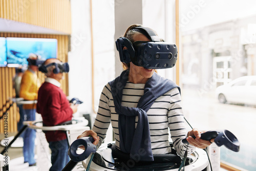 Senior woman using a vr headset and controllers photo