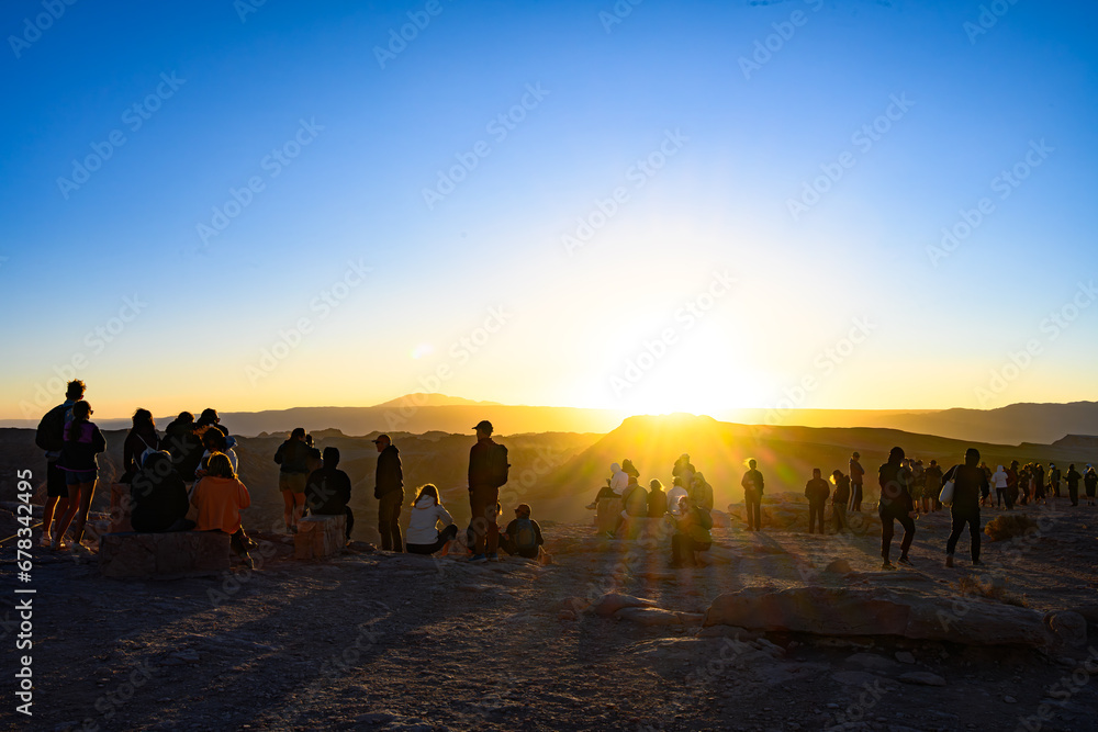 Pessoas admirando o por do sol no Vale da Lua (Valle de La Luna) no Deserto do Atacama, Chile. 2023.