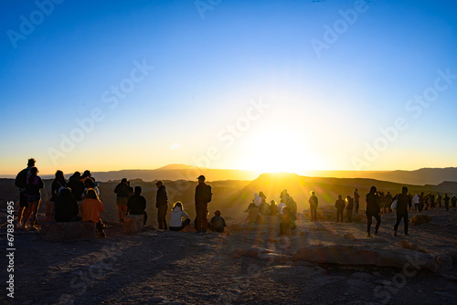 Pessoas admirando o por do sol no Vale da Lua (Valle de La Luna) no Deserto do Atacama, Chile. 2023.