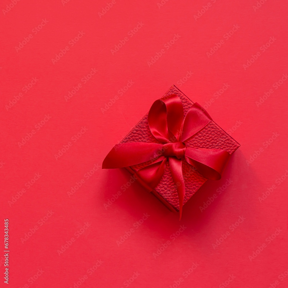 Red (scarlet) box (gift) on a red background. Festive concept, present for birthday, Christmas, Valentine's day, mothers Day. Red (scarlet) box (gift) on a red background. Festive concept, present for birthday, Christmas, Valentine's day, mothers Day.