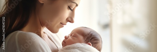  Extreme close-up of a loving mother and her newborn, set against a soft white background photo