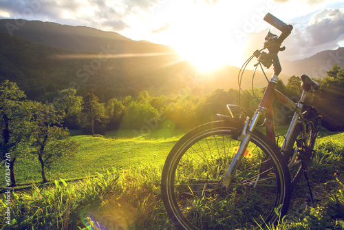 Fahrrad im Gegenlicht in schöner grüner Landschaft mit Sonne im Sommer