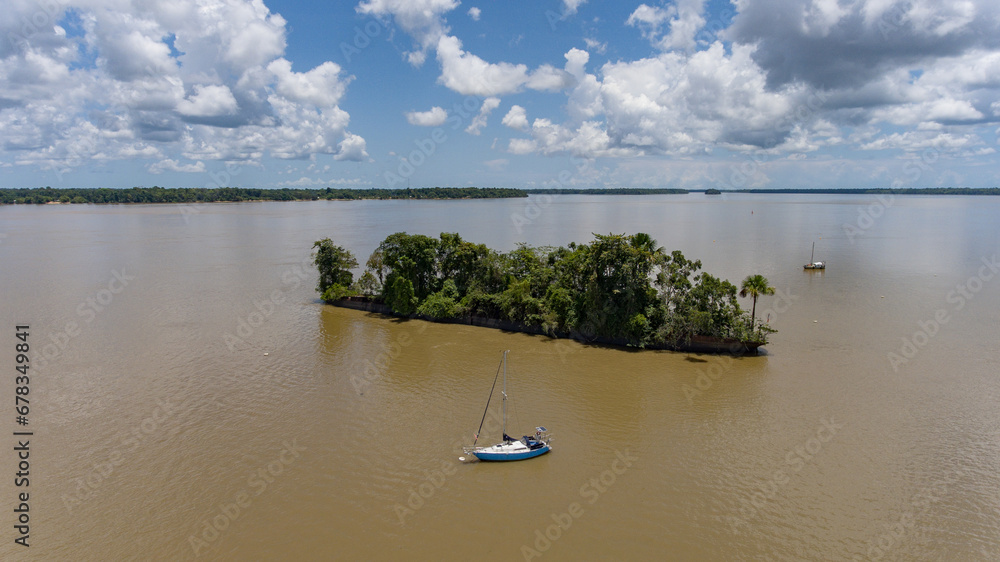 French Guiana prison ship covered by lush vegetation sailing boat aerial river
