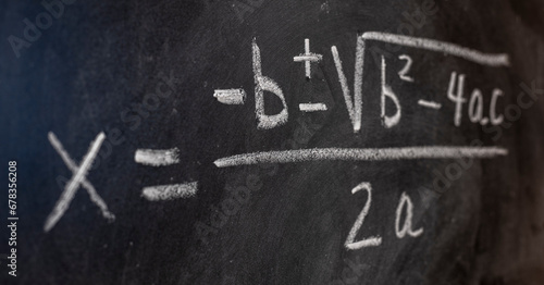 Ecuaciones cuadráticas escrito a mano en una pizarra con tiza, fórmulas matemáticas photo