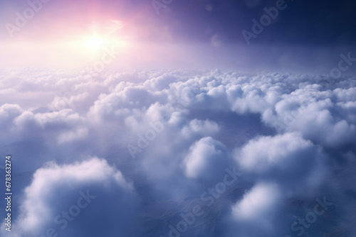 Fluffy clouds with the sun casting a soft glow in a clear blue sky © gankevstock