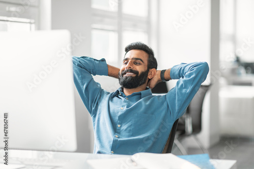 Relaxed indian businessman taking break at work