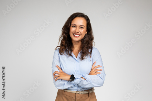 Smiling friendly confident millennial caucasian lady manager, teacher in formal wear with crossed arms photo