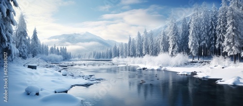 The winter landscape with snow covered trees against the backdrop of a dark blue sky creates a stunning natural scene where the glistening water reflects the light forested mountains © TheWaterMeloonProjec