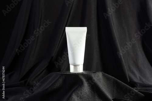 clean white tube mockup of hand cream on dark black background.