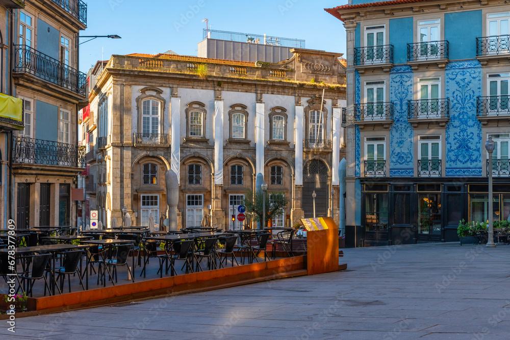Sidewalk cafe in the city center of Porto with colorful buildings with nobody. Medieval architecture with empty restaurant of Oporto downtown, Portugal at sunrise. Travel destination