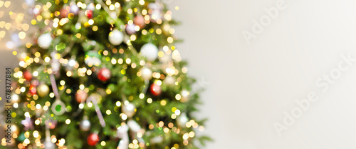 Defocus blurred background with elegant fir, garlands, highlights. Beautiful festive Christmas tree, New Year's Eve and Christmas. Festive postcard, concept of the holiday