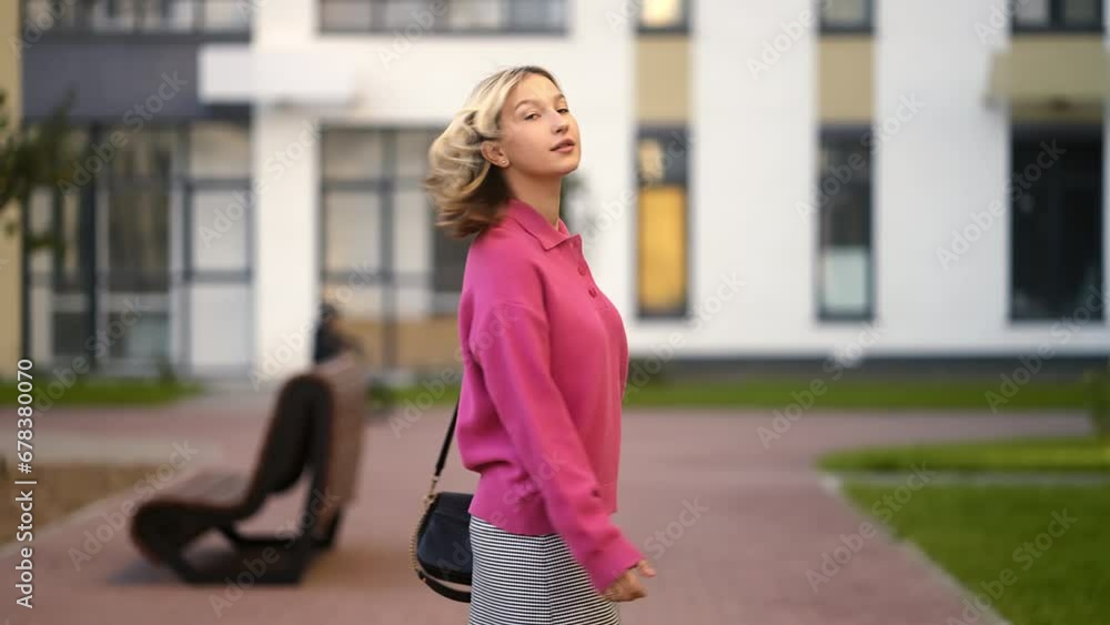 A blonde girl in a pink sweater walks through a modern residential complex. He chooses an apartment in a new building. Mysteriously unfolding in slow motion A blonde girl in a pink sweater walks through a modern residential complex. He chooses an apartment in a new building. Mysteriously unfolding in slow motion