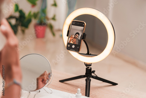 Influencer creating content using ring light and smartphone photo