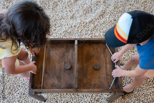 Two children working together on a wooden drawer photo
