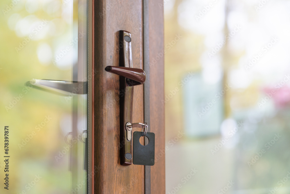 Key with key fob in the keyhole of a closed door Key with key fob in the keyhole of a closed door