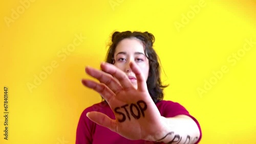 Video of close-up of a woman's hand with the word stop written on it. Concept of struggle and equality of women's rights. Women's day. photo