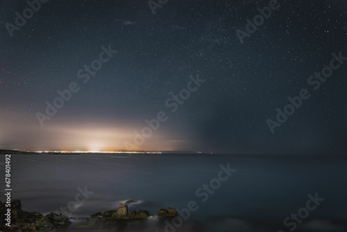 Rocky coast under the scenic starry sky at night