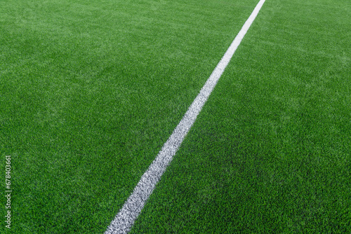 Fototapeta Naklejka Na Ścianę i Meble -  Green synthetic grass sports field with white line shot from above. Soccer, hurling, lacrosse, rugby, football, baseball sport concept