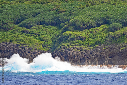 Pacific Ocean waves crash against the shores of Niue and the air is filled with spray.