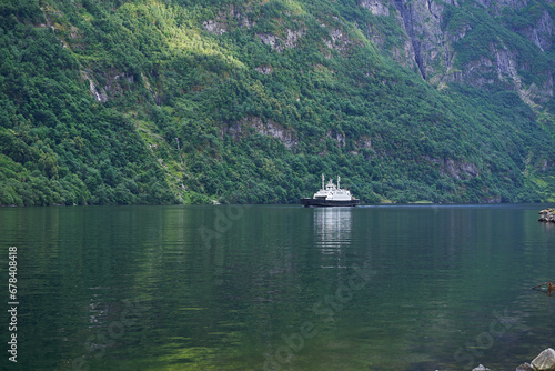 Small and local ferry boat operated in the large norwegian fjord in Aurland mountainous and wooded region of Norway. Neccesary transport solution for local citizens of small villages along the fjord. photo