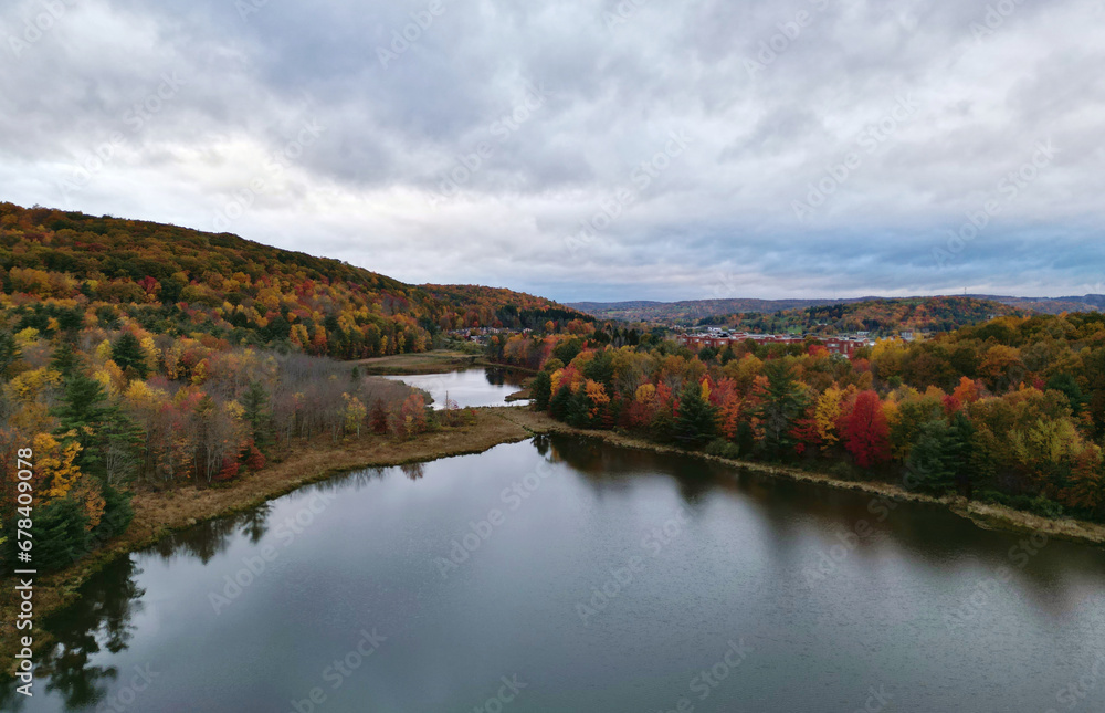 marsh with lake (aerial view in autumn with fall foliage) binghamton university nature preserve hiking trail with bridge in wetland, swamp (colorful leaves, hills) from above, nature walk marsh with lake (aerial view in autumn with fall foliage) binghamton university nature preserve hiking trail with bridge in wetland, swamp (colorful leaves, hills) from above, nature walk