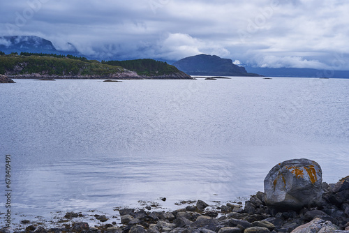 Landscape picture of the dramatic scandinavian coast of norwegian sea on the island Otroya in the middle of Norway. Picture is taken during beautiful summer calm and cloudy sunset in the blue hour. photo