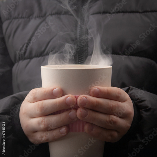 Warm mug in hands, winter mood, black jacket, cozy ambiance.