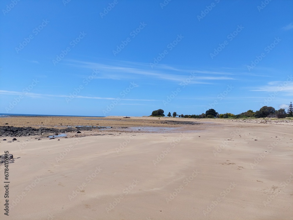 Beautiful view sandy ground with coast trees under blue cloud sky in Devonport, Australia Beautiful view sandy ground with coast trees under blue cloud sky in Devonport, Australia