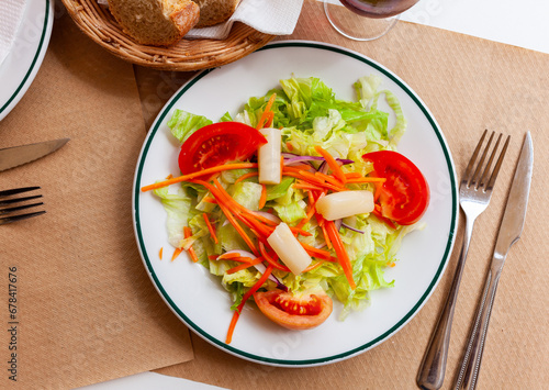 Refreshing salad with chopped tomatoes, sliced onion, carrot and greens