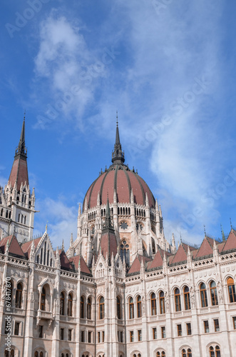 Vertical shot of the Hungarian Parliament Building on blue cloudy sky background