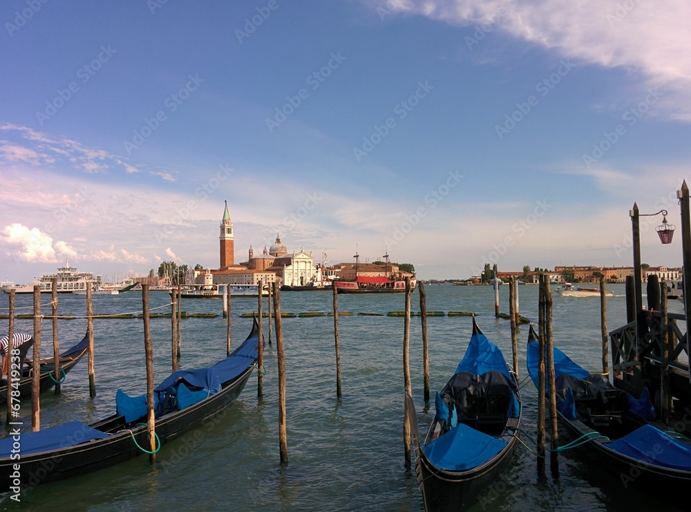 Beautiful shot of gondolas moored at docks on a background of Venice, Italy