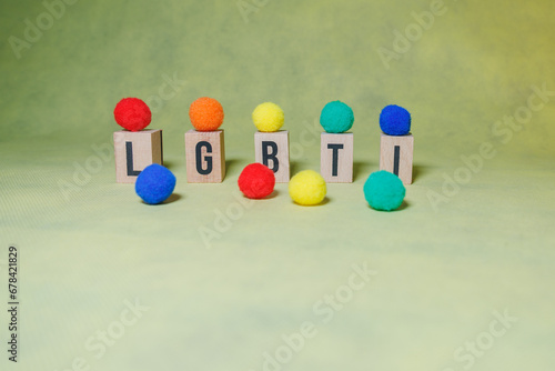 LGBTI word with wooden letters decorated with different colored balls with yellow background