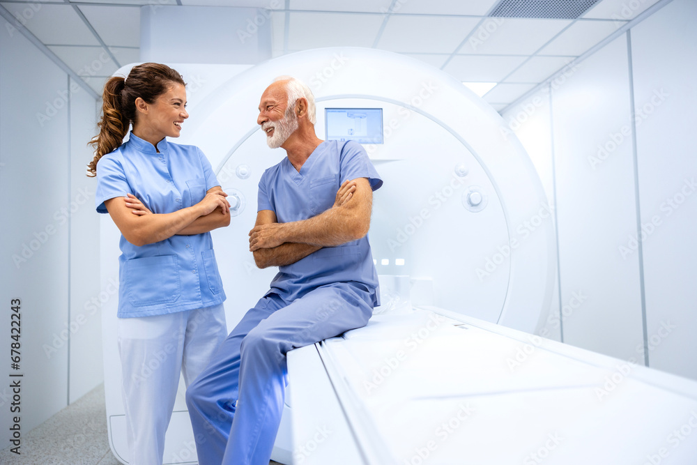 Obraz premium Female doctor preparing and encouraging senior man before MRI scan or CT procedure in hospital.