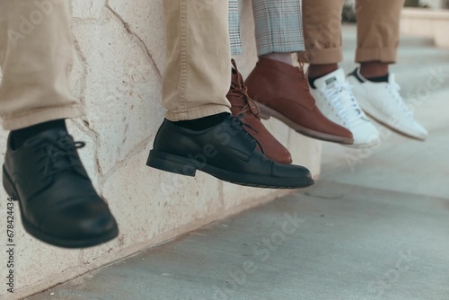 People sitting on a wall with their feet hanging