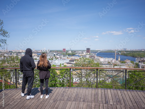 ukrainians couple viewing scenery of old city podil from observation deck in a sunny day photo