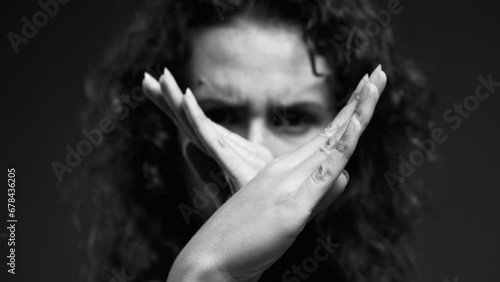 Upset Woman Making 'X' with Hands and Pointing Finger at Camera, Waving 'NO' in Rejection in intense monochromatic, black and white photo