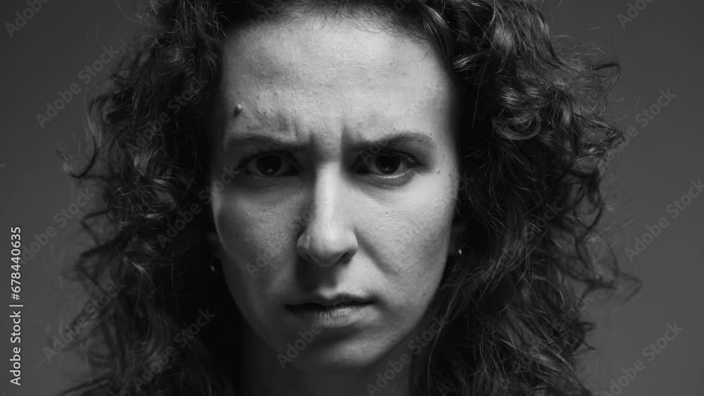Upset Woman with Frowned Eyebrows, Serious Expression Directly Looking at Camera in intense monochromatic, black and white Upset Woman with Frowned Eyebrows, Serious Expression Directly Looking at Camera in intense monochromatic, black and white