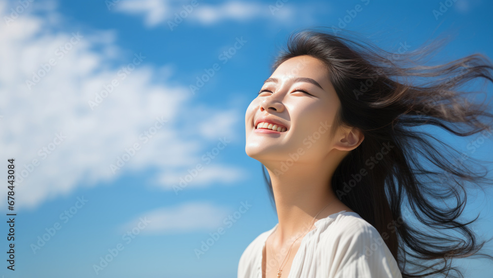 A Asian woman breathes calmly looking up isolated on clear blue sky A Asian woman breathes calmly looking up isolated on clear blue sky