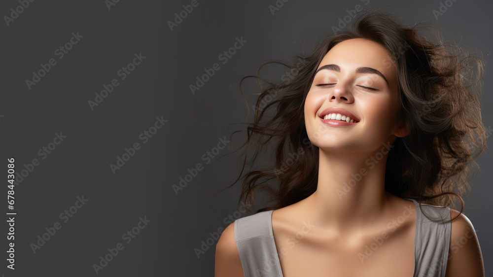 A brunette woman breathes calmly looking up isolated on gray background