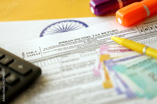 Indian income tax return blank form with pen and indian rupees bills on indian country flag close up. Annual tax report concept photo