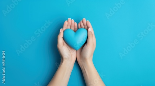 A blue heart held by two hands on a blue background, representing affection and compassion