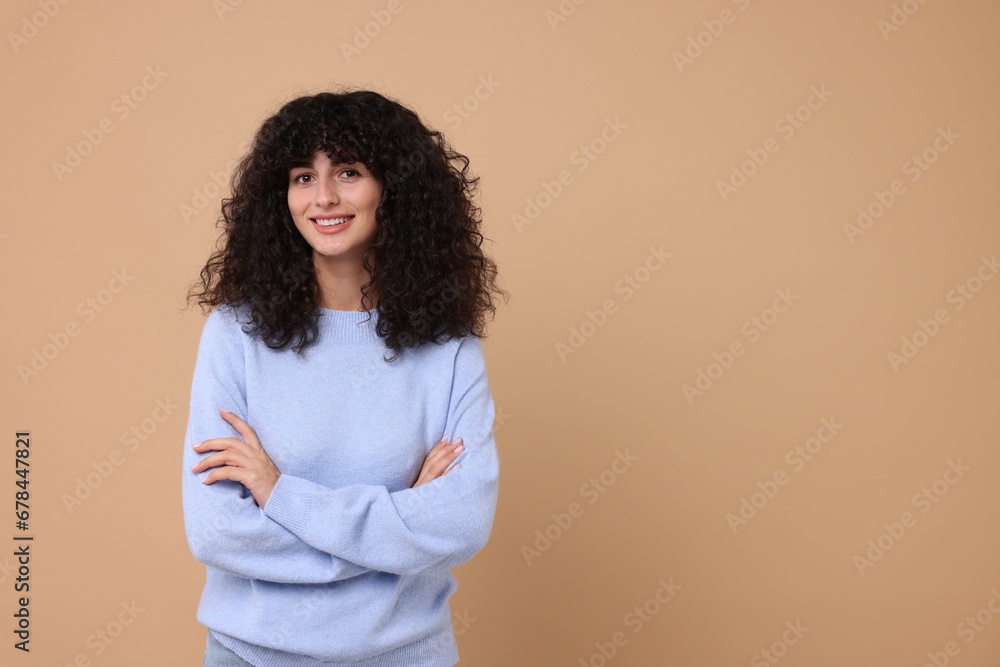Happy young woman in stylish light blue sweater on beige background, space for text Happy young woman in stylish light blue sweater on beige background, space for text