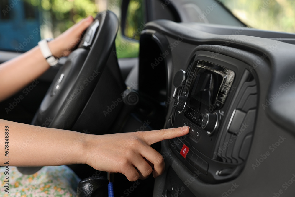 Choosing favorite radio. Woman pressing button on vehicle audio in car, closeup