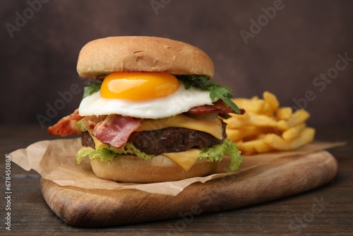 Delicious burger with fried egg on wooden table, closeup
