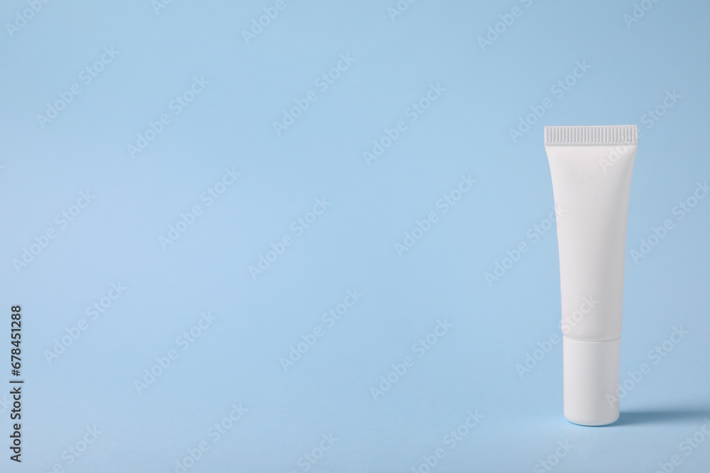 One lip balm on light blue background, space for text One lip balm on light blue background, space for text